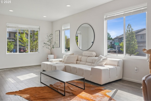 living room with recessed lighting, baseboards, a wealth of natural light, and hardwood / wood-style flooring