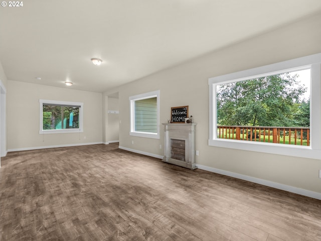 unfurnished living room with hardwood / wood-style flooring, a fireplace, and a wealth of natural light