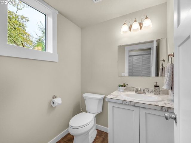 bathroom with toilet, hardwood / wood-style floors, and vanity