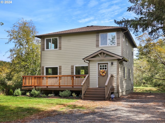 rear view of house featuring a yard and a deck