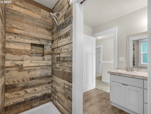 bathroom featuring vanity, wood walls, and walk in shower