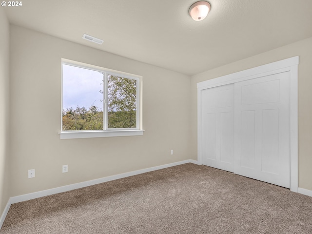 unfurnished bedroom with a closet and carpet flooring