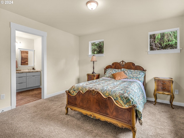 bedroom with light colored carpet and ensuite bath