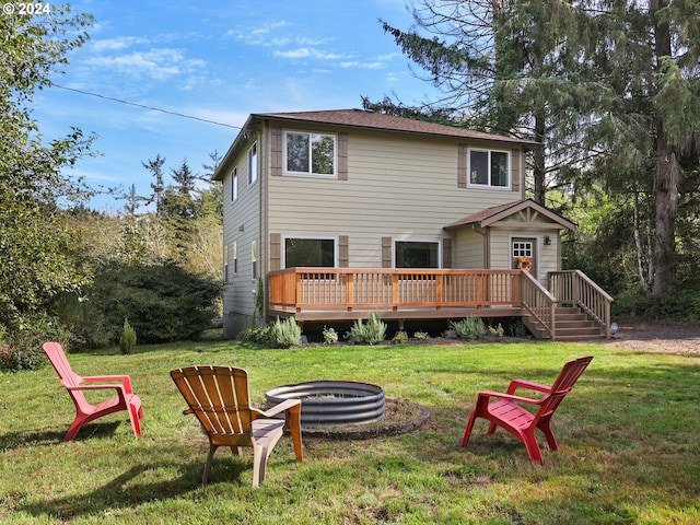 rear view of property with an outdoor fire pit, a yard, and a wooden deck