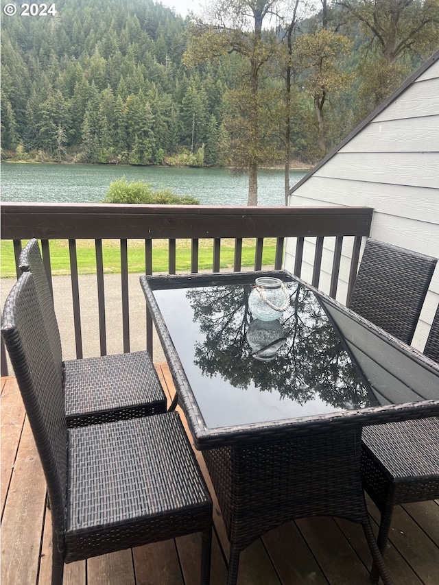 wooden deck with a lawn and a water view