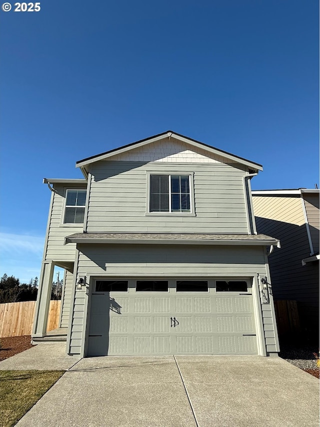 view of front facade featuring concrete driveway, a garage, and fence