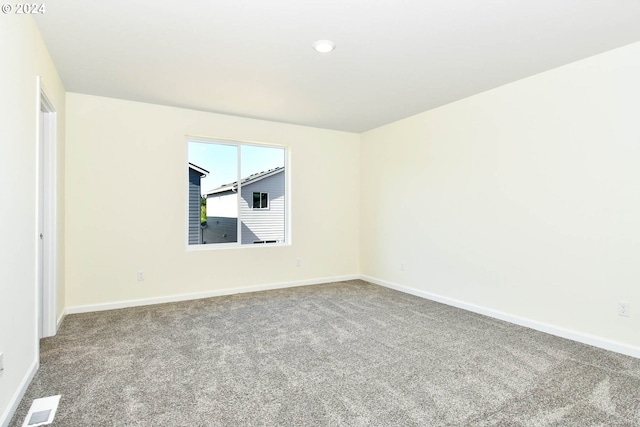 empty room with visible vents, baseboards, and carpet floors