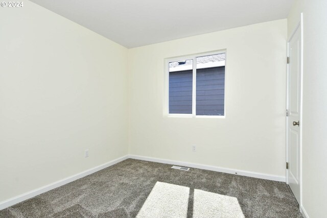 unfurnished room with visible vents, carpet, and baseboards