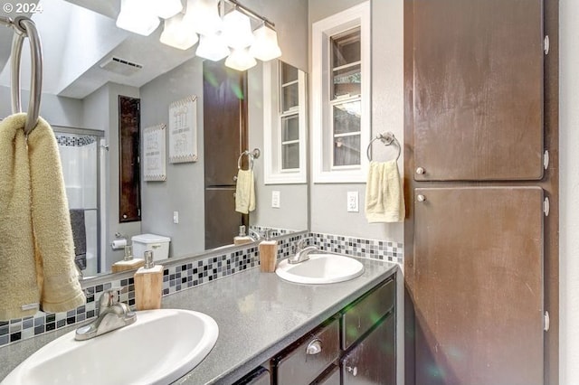 bathroom with decorative backsplash, vanity, and toilet