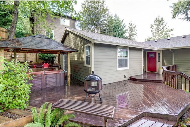 wooden terrace featuring a gazebo and a hot tub