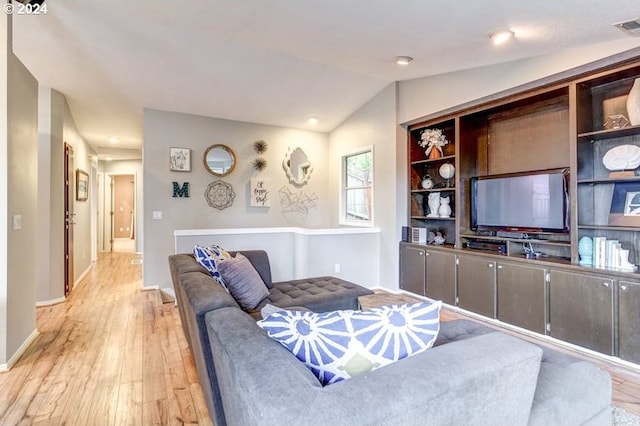 living room featuring light hardwood / wood-style flooring and vaulted ceiling