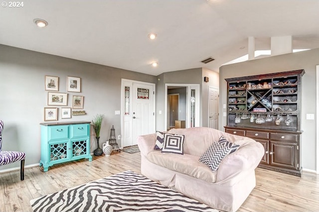 living room featuring light hardwood / wood-style floors and vaulted ceiling