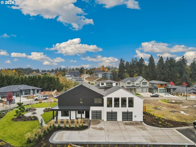 back of house featuring a garage, a residential view, and concrete driveway