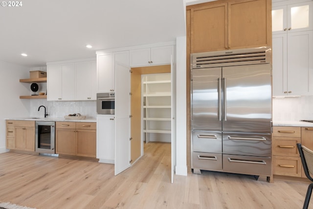 23141 SW Curry Ridge Dr, Sherwood, OR 97140 - kitchen with stainless steel appliances, beverage cooler, open shelves, decorative backsplash, and light wood-style flooring
