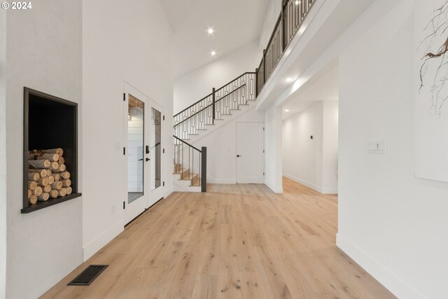 foyer featuring a towering ceiling and light hardwood / wood-style flooring