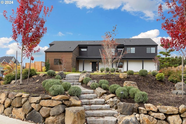 view of front of property featuring metal roof and fence