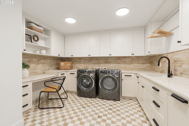 laundry area featuring a sink, cabinet space, light floors, and washing machine and dryer