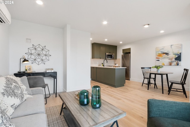 living room with light hardwood / wood-style floors, a wall mounted AC, and sink