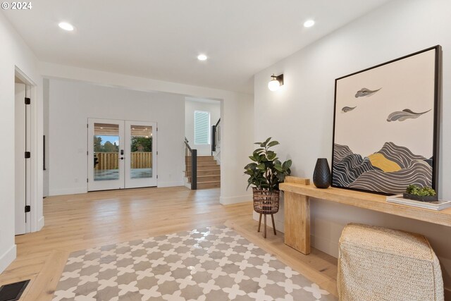 hallway with french doors and light hardwood / wood-style floors