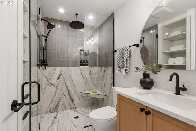 bathroom with a shower with shower door, vanity, and toilet