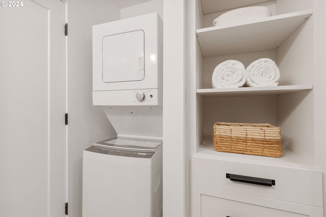 washroom with stacked washer / drying machine and laundry area