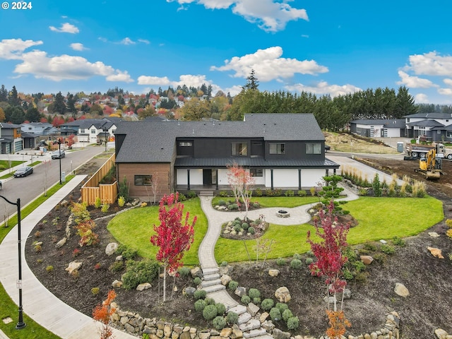 rear view of property with metal roof, a residential view, a lawn, and fence