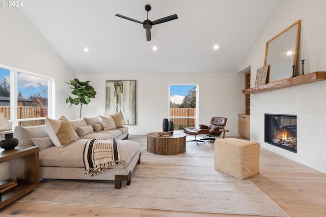 living room with ceiling fan, light hardwood / wood-style flooring, and high vaulted ceiling