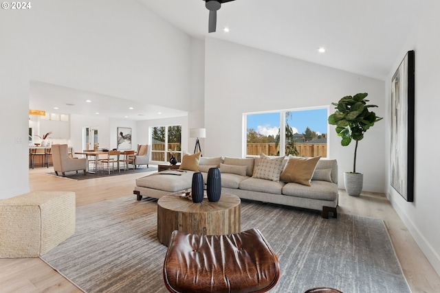 living room with high vaulted ceiling, light hardwood / wood-style floors, a healthy amount of sunlight, and ceiling fan