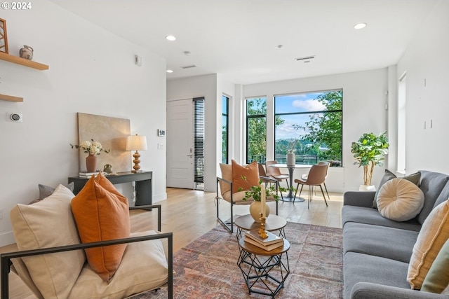 living room with light wood-type flooring and recessed lighting