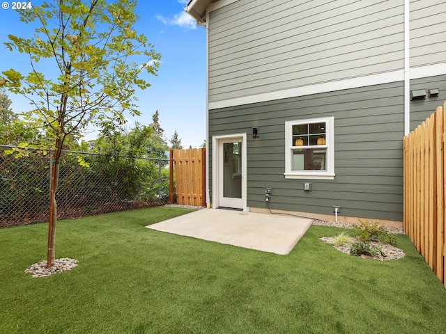 back of property featuring a lawn, a patio area, and fence