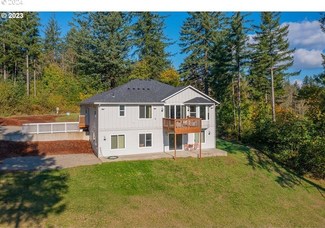 back of property with a lawn, a patio area, and a deck