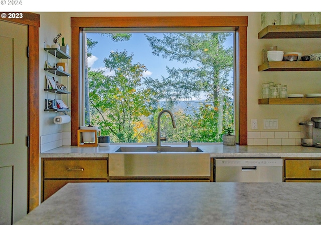 kitchen featuring decorative backsplash, white dishwasher, and sink