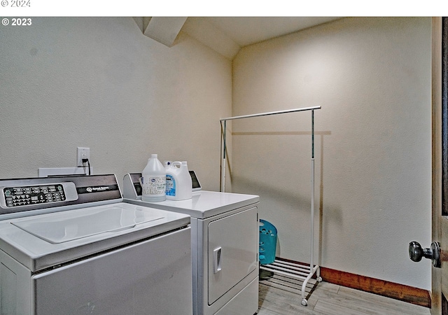 laundry room featuring light wood-type flooring and separate washer and dryer