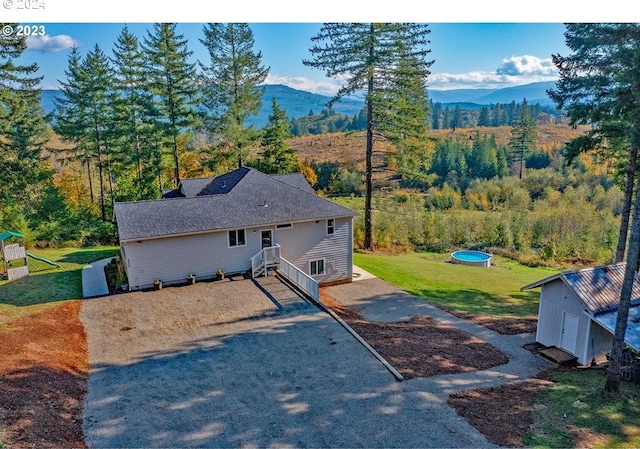 exterior space with a mountain view and a front yard