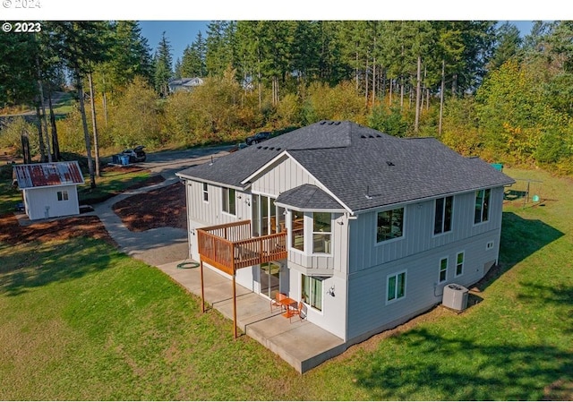 rear view of property featuring a lawn, central AC unit, a patio area, and a deck