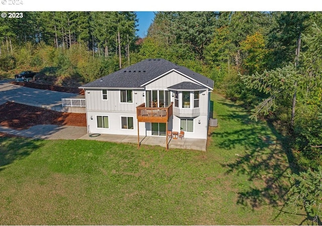 rear view of house featuring a yard, a patio, and a deck