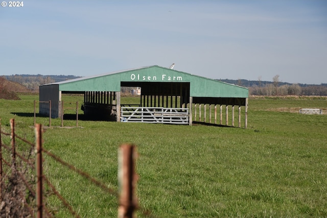 view of outdoor structure featuring a rural view and a lawn