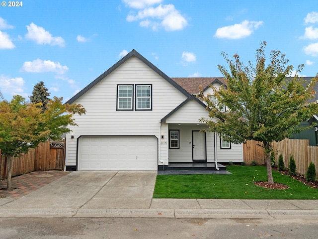 view of front of house featuring covered porch, a garage, and a front yard