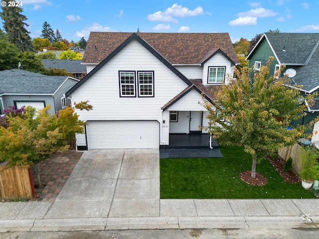 view of front of home featuring a garage, a front yard, and a porch