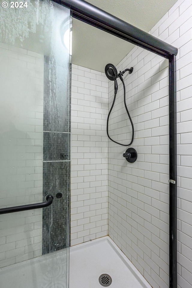 bathroom featuring a textured ceiling and walk in shower