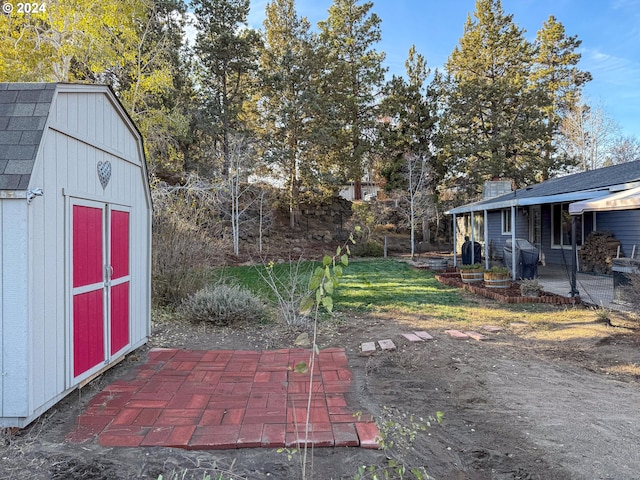 view of yard with a patio area and a storage shed