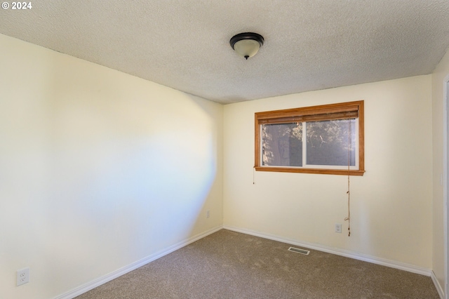 carpeted empty room with a textured ceiling