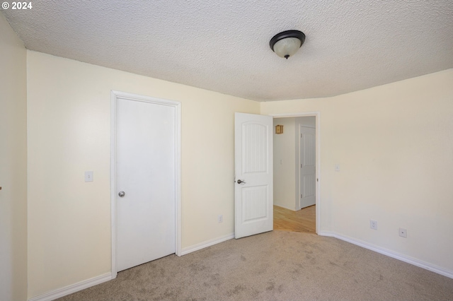 carpeted empty room featuring a textured ceiling