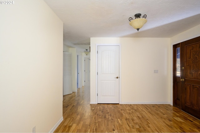 foyer with a textured ceiling and light hardwood / wood-style flooring