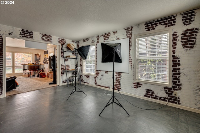 workout room with a textured ceiling and brick wall