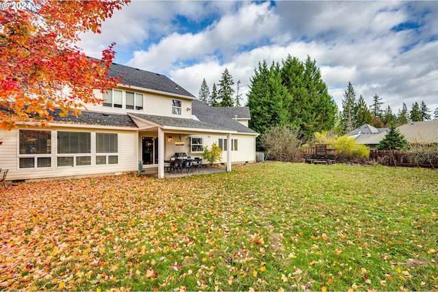 rear view of house with a lawn, a patio area, and central AC unit