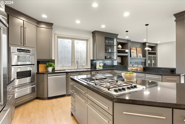 kitchen with stainless steel appliances, sink, pendant lighting, light hardwood / wood-style flooring, and gray cabinets