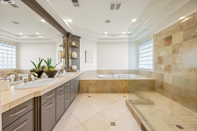 bathroom featuring tile patterned floors, vanity, tiled bath, and a tray ceiling