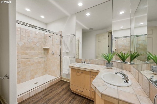 bathroom featuring hardwood / wood-style floors, vanity, and a shower with door