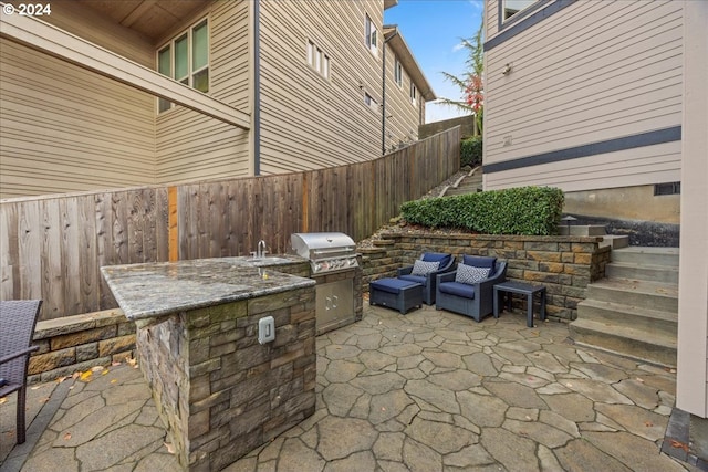 view of patio / terrace with a grill, sink, and an outdoor kitchen